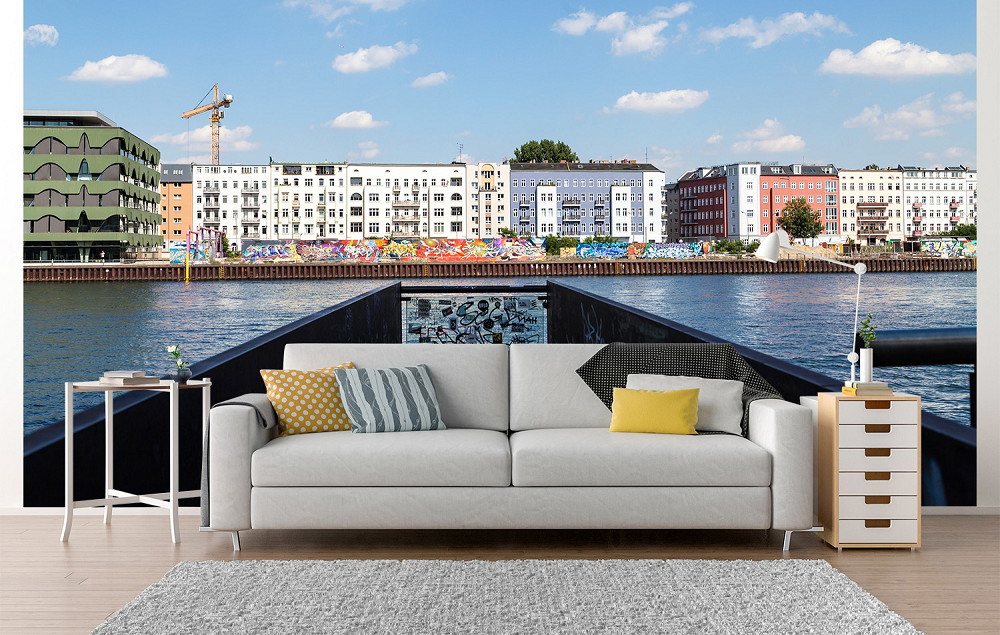 Fototapete - Blick über einen Kanal auf eine Stadtfassade mit buntem Graffiti und modernen Gebäuden im Hintergrund