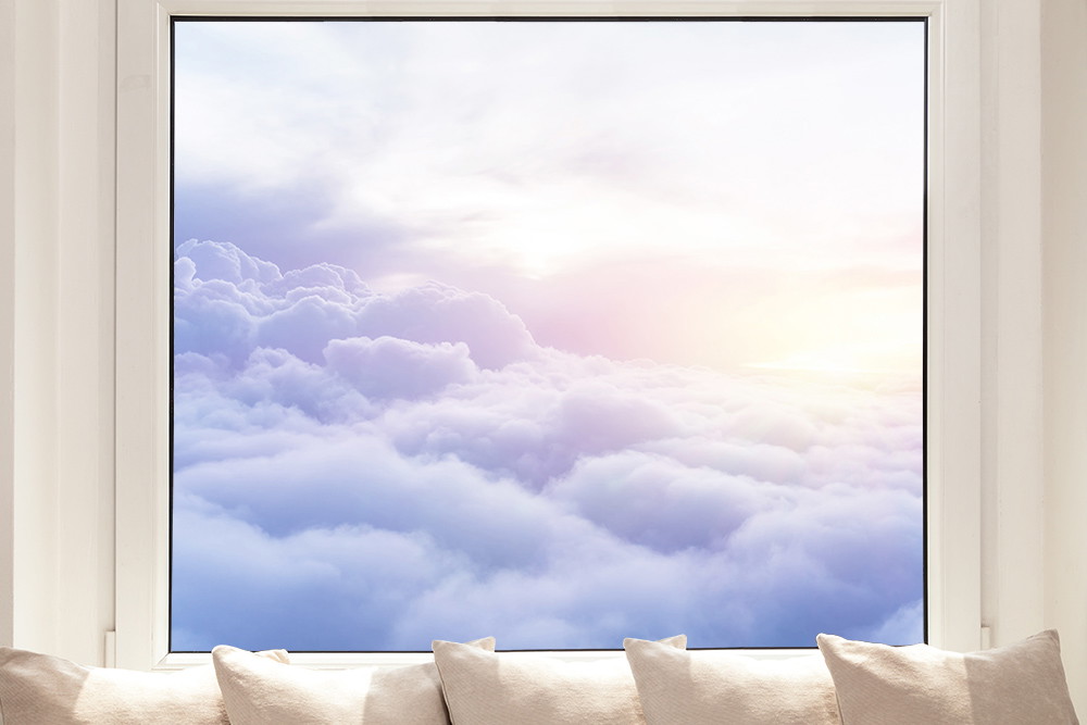 Fensterfolie - Blick aus einem Fenster auf einen weichen Wolkenhimmel bei Sonnenaufgang, ideal für eine beruhigende Raumdekoration