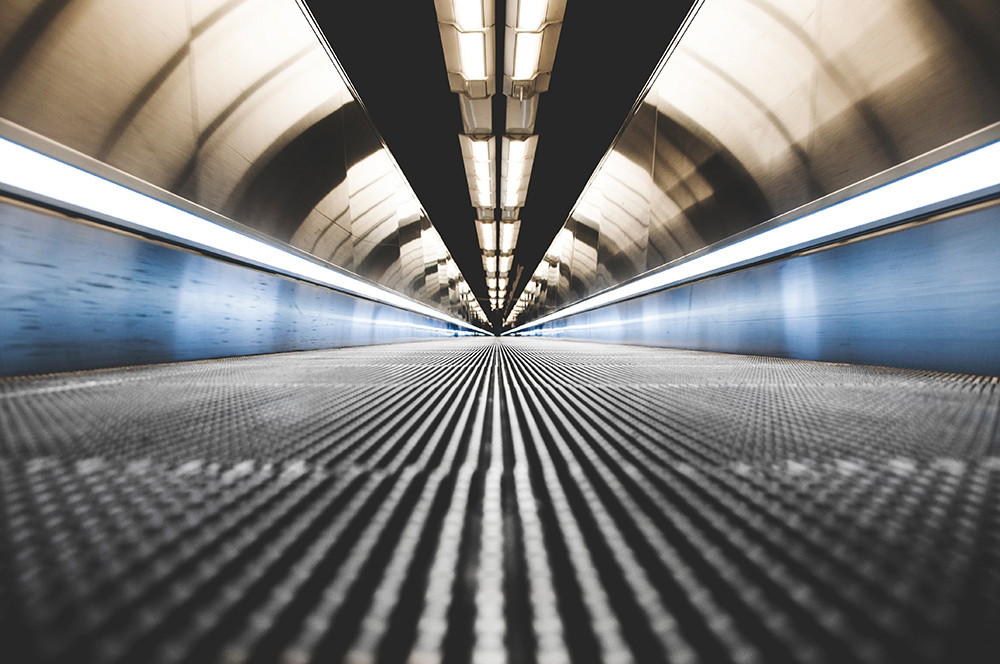 Wall mural - View into a modern tunnel with geometric lines and futuristic lighting