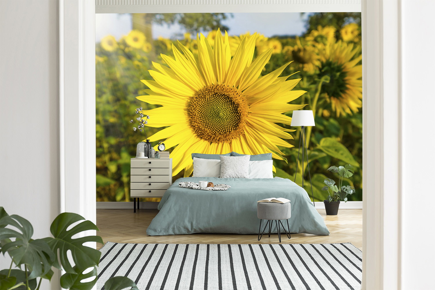 Fotobehang - Slaapkamer met een groot zonnebloembehang achter het bed voor een natuurlijke sfeer