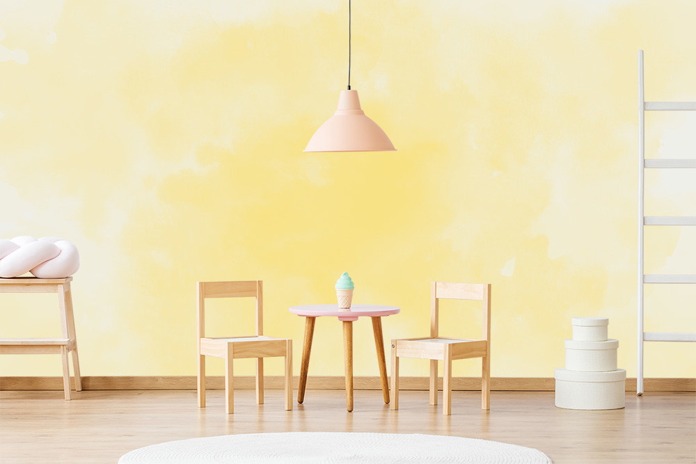 Papier peint photo - chambre d'enfant décorée dans un style scandinave avec des tons jaunes doux, des chaises en bois, une petite table et des jouets