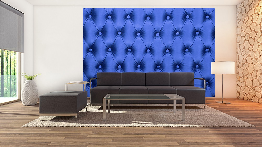 Muurschildering - Moderne woonkamer met blauw gewatteerde wandbekleding achter een zwarte bank
