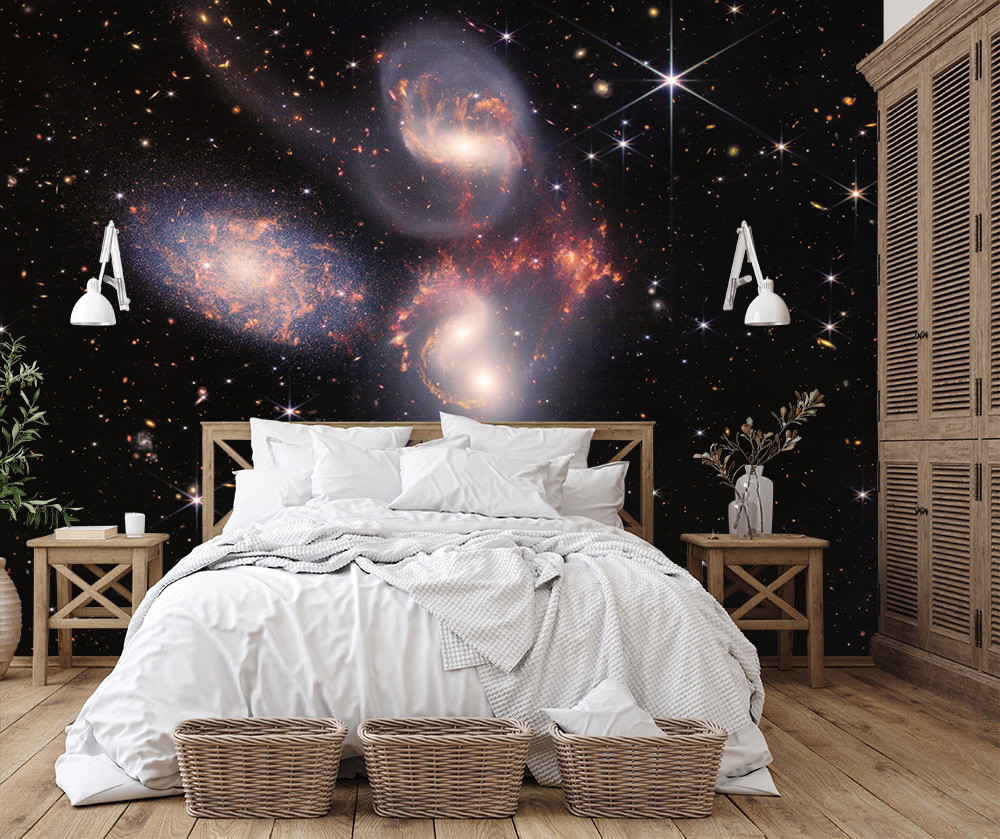 Wall mural - galaxy design in bedroom showing a bed with white cushions and wooden furniture