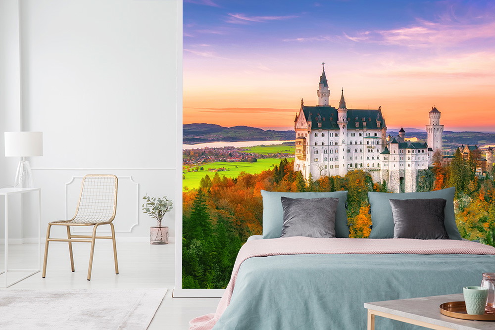 Fototapete - Schlafzimmer mit Fototapete des Schlosses Neuschwanstein, umgeben von Herbstbäumen und einem bunten Sonnenuntergang