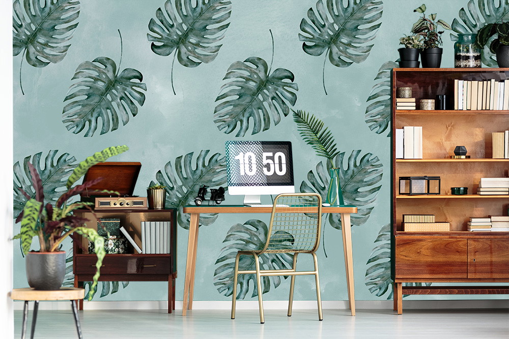 Papier peint photo - Bureau moderne avec papier peint au design de feuilles de monstera, bureau en bois et armoires, entouré de plantes