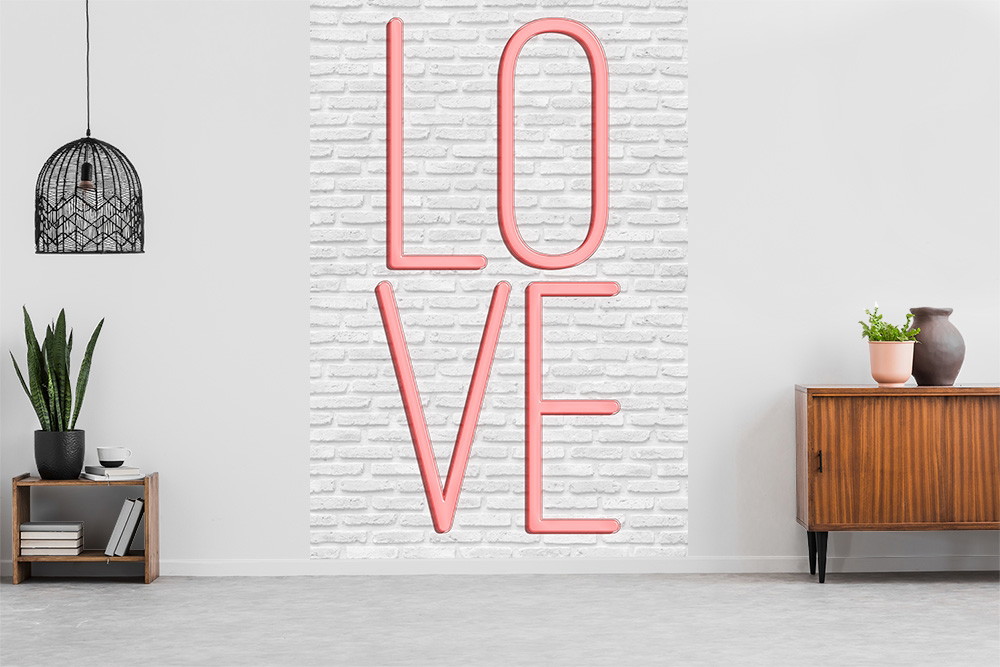 Fototapete - Raum mit weißer Ziegelwand und großem pinkfarbenen LOVE-Schriftzug, umgeben von minimalistischer Dekoration