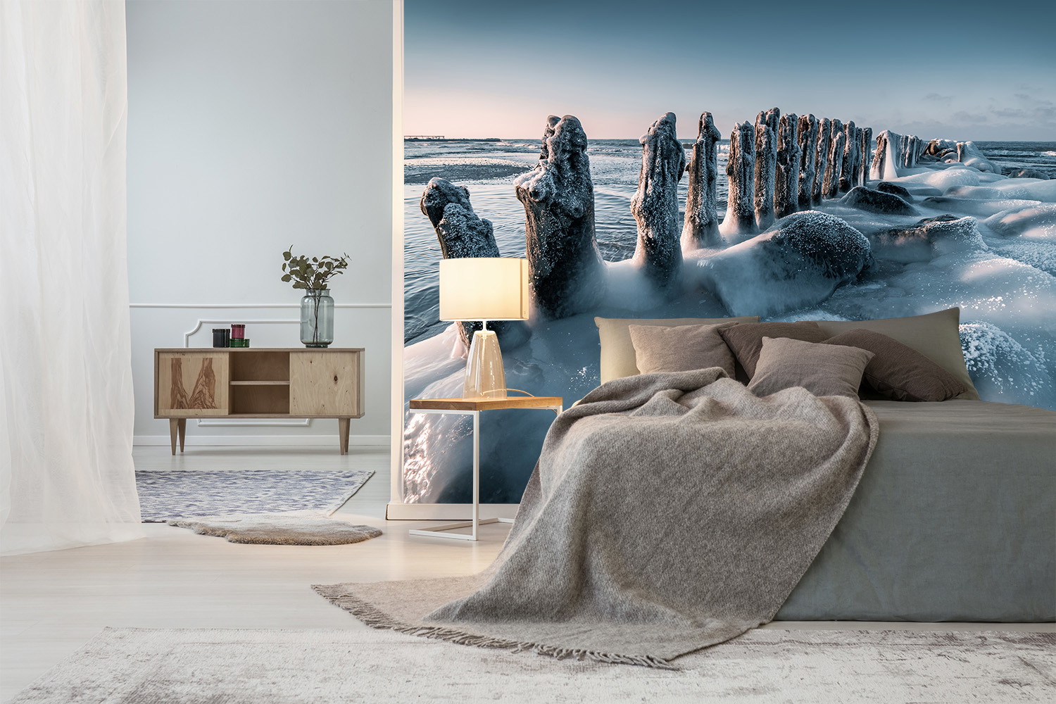 Wall mural - detailed view of a bedroom with an impressive winter coastal scene showing frozen wooden piles and oceanic waves