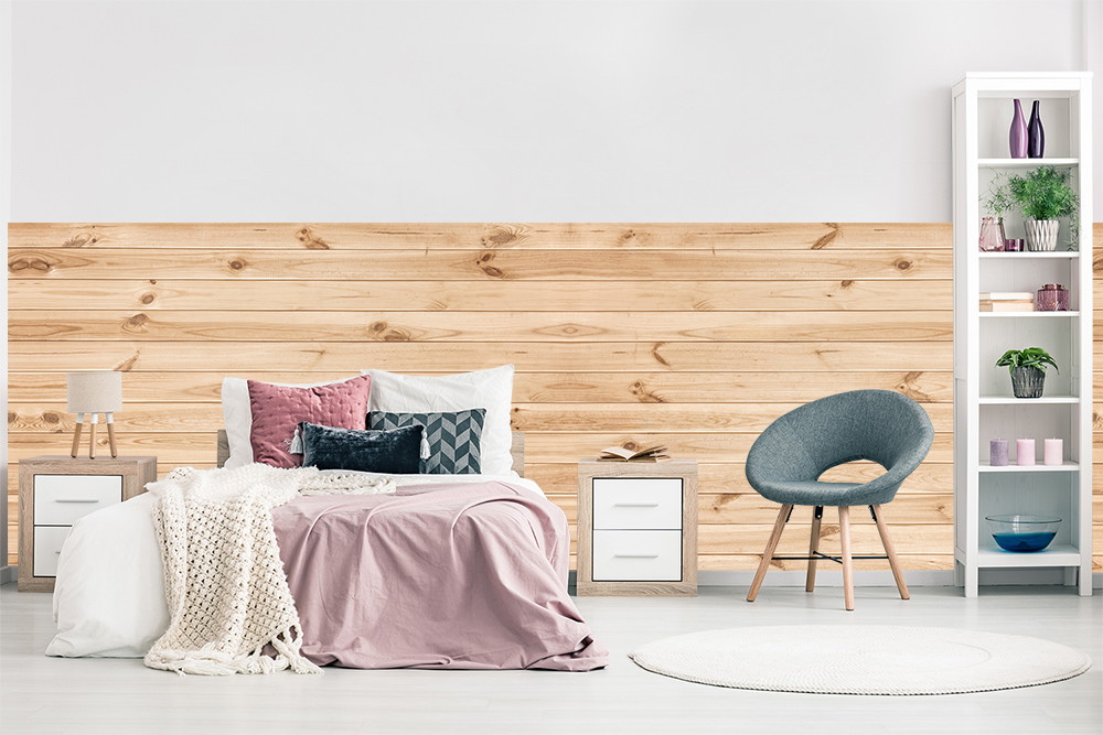Fototapete - Gemütliches Schlafzimmer mit Holzwand, dekorativen Kissen und modernem Stuhl