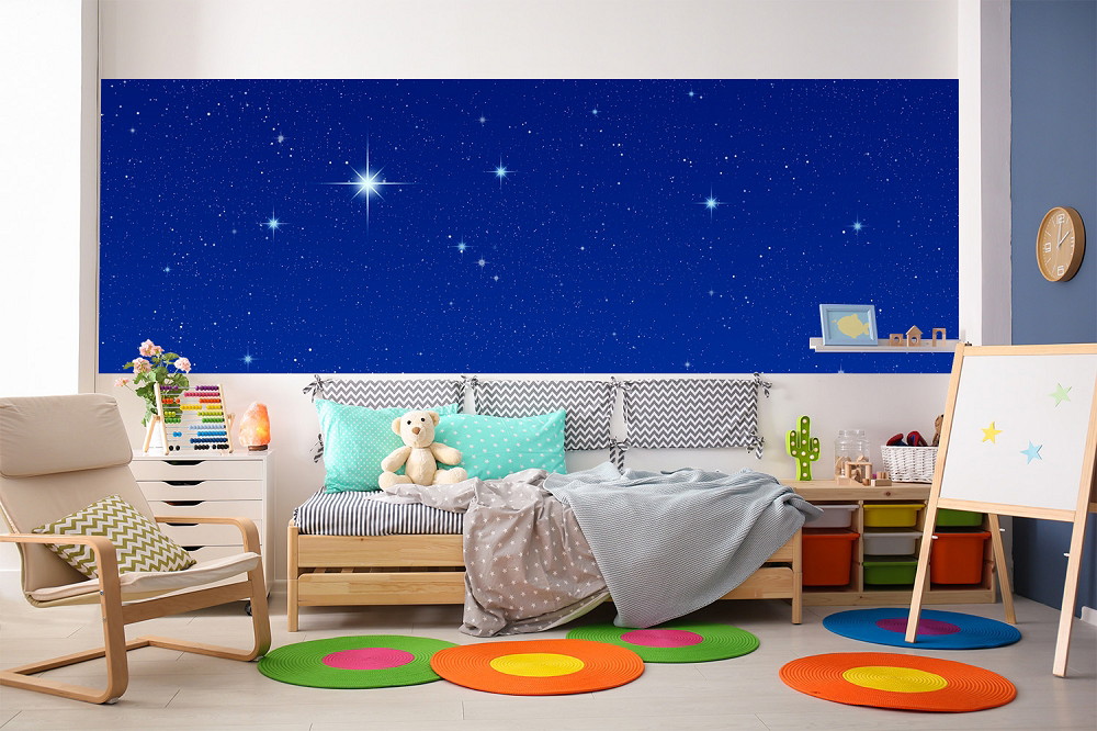 Wall mural - children's room with blue starry wall design, wooden furniture, colourful carpets and toys