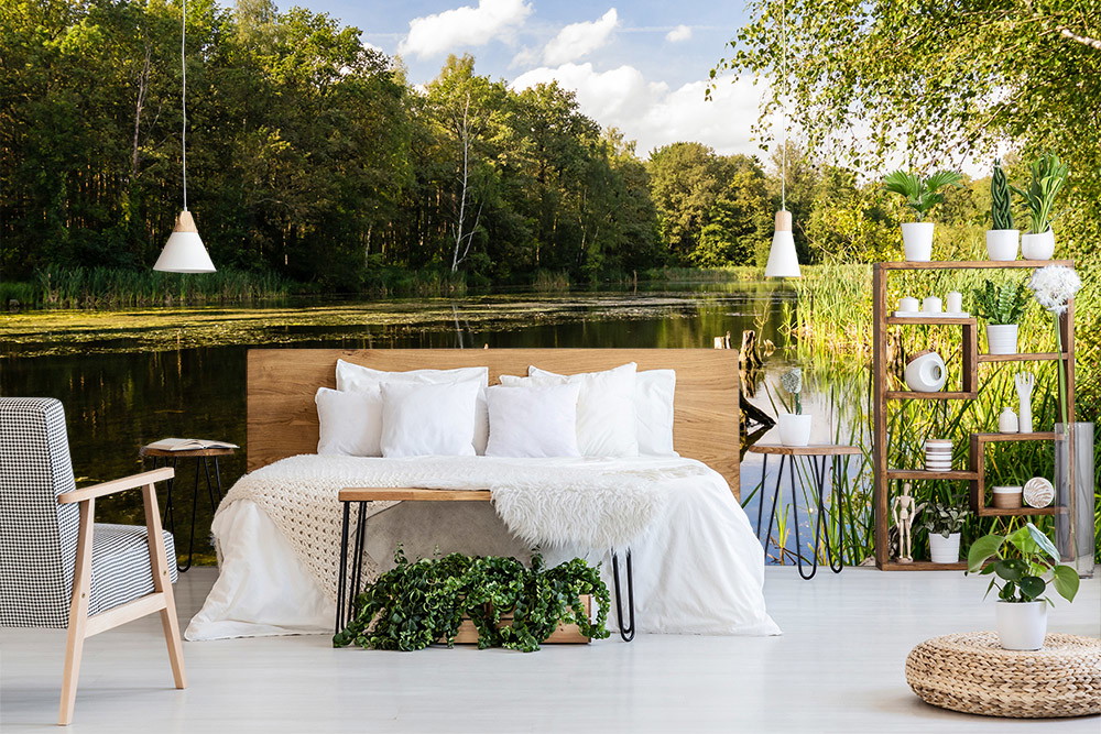Fotomurale - Camera da letto con scaffali in legno, piante e paesaggio marino sullo sfondo