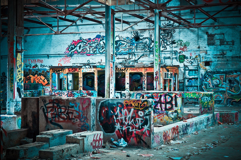 Papier peint photo - Intérieur d'un vieux bâtiment abandonné avec des graffitis colorés sur les murs et un tramway antique.