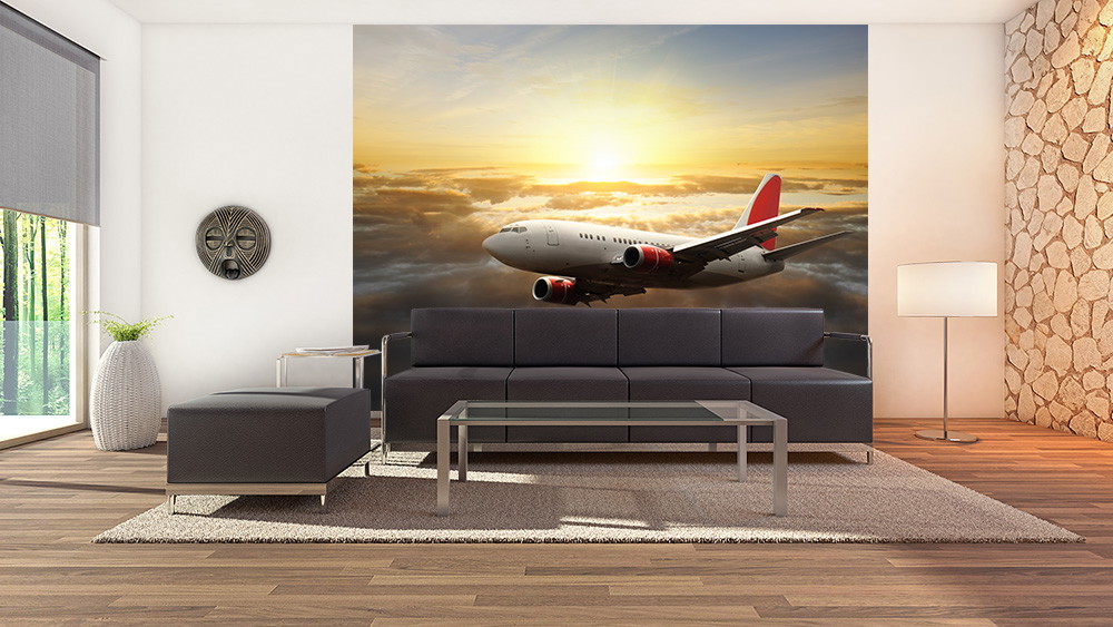 Wall mural - An aeroplane flying over clouds at sunset, decorates a living room wall with modern furniture.