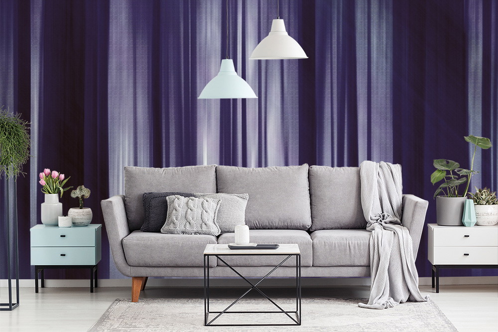 Fotomurale - Soggiorno elegante con parete a righe viola, divano grigio e piante decorative