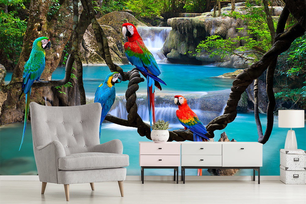 Fototapete - Bunte Papageien sitzen auf Ästen vor einem Wasserfall in einer grünen Waldlandschaft