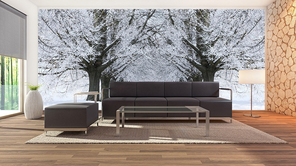 Wall mural - Modern living room with wall mural of snow-covered trees depicting a peaceful winter landscape